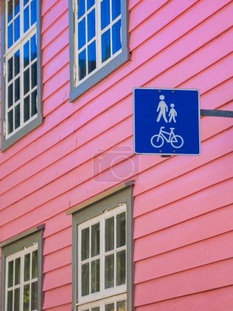 Téléchargez les photos : Panneau piéton coloré par la façade rose avec vélo et marche en architecture urbaine - en image libre de droit