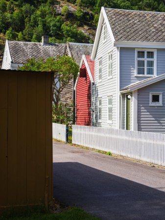 Téléchargez les photos : Chalet en bois pittoresque dans un village norvégien avec façade complexe et cadre luxuriant. - en image libre de droit