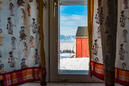 Verschneiter Winterhimmel durch ein Innenfenster in Grönland.