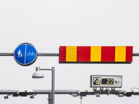 Against a backdrop of overcast skies, a clear indication for pedestrians and cyclists is presented next to a red and yellow barrier, suggesting a restricted area in Gothenburg, Sweden. Below, a streetlight hangs silently, while a price tag showing 22