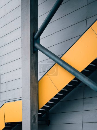 Un escalier jaune vif se dresse à côté d'un bâtiment moderne à Gothenburg, en Suède. L'escalier donne accès au bâtiment et ajoute une touche de couleur au paysage urbain.