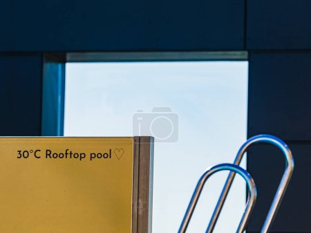 A partial view of a sunny sky frames the scene over a 30C rooftop pool in Gothenburg, Sweden. The warm glow of the sun hints at a perfect day for a swim. 