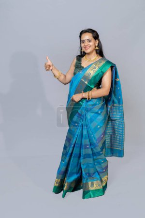 Photo for Portrait of Indian woman in saree showing thumbs towards camera .Full portrait of south Indian woman in saree - Royalty Free Image