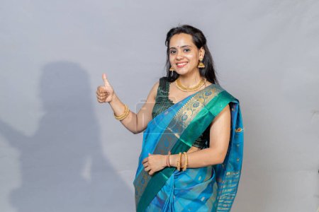 Photo for Portrait of Indian woman in saree showing thumbs towards camera .Full portrait of south Indian woman in saree - Royalty Free Image