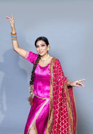 Photo for A Punjabi woman dancing in joy studio shot on background - Royalty Free Image