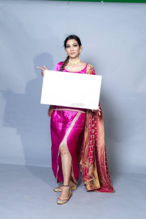 Photo for A Punjabi woman with sign board looking towards the placing card studio shot - Royalty Free Image