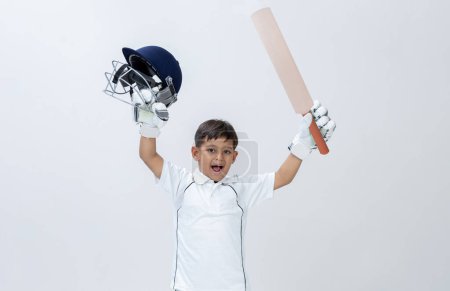 Photo for Kid in cricket dress holding bat and Helmet celebrating Century on isolated background Studio shot, cricket concept - Royalty Free Image