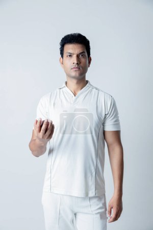 Photo for Portrait of Cricketer holding cricket boll in hand and looking towards the camera in aggression , Cricket concept shoot - Royalty Free Image
