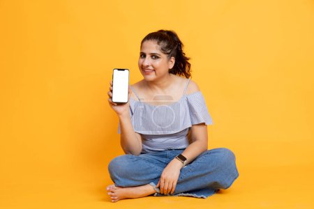 Photo for Indian female showing phone screen towards the screen ,mobile app advertisement concept - Royalty Free Image