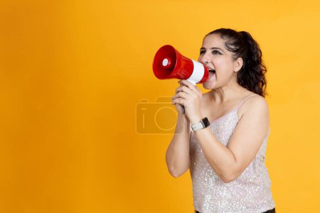 Photo for Indian girl shouting on mega phone announcing offer and deals - Royalty Free Image