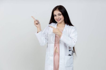 Photo for Portrait of Indian female doctor pointing towards the empty space, copy space - Royalty Free Image
