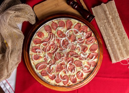 pepperoni pizza on wooden background. Brazilian pizza called pizza de calabresa. top view