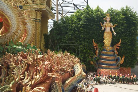 Téléchargez les photos : Statue d'un ange tenant un lotus debout sur un serpent pour protéger la place et la statue du groupe de mains au temple Wat Maniwong. Situé dans la province de Nakhon Nayok en Thaïlande. - en image libre de droit