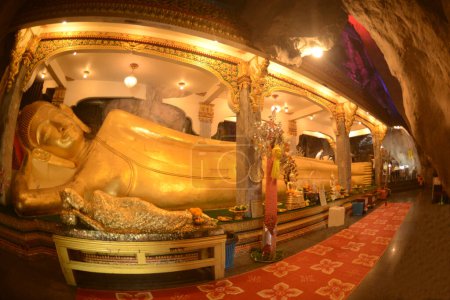 Golden Reclining Buddha in various postures are enshrined inside the famous Tham Khao Yoi Temple. And there are beautiful stalagmites and stalactites. Located at Phetchaburi Province in Thailand.