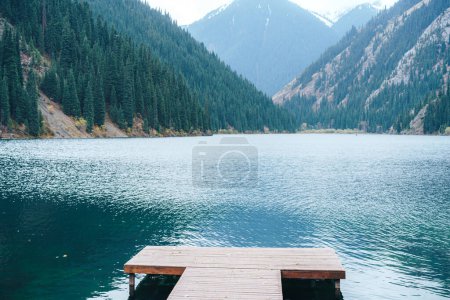 Wooden pier in the middle of a mountain lake.