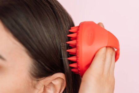 Téléchargez les photos : Lady taking care of hair and scalp with scalp massager. - en image libre de droit