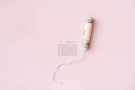 Téléchargez les photos : Tampon enveloppé dans un billet d'un dollar sur un fond rose. - en image libre de droit