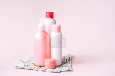 Téléchargez les photos : Tubes avec produits d'hygiène sur billets d'un dollar sur fond rose. - en image libre de droit