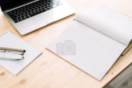 Photo for Blank blank notepad with laptop on wooden table. - Royalty Free Image