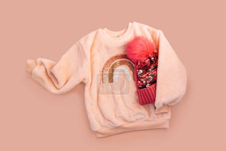 Photo for Childrens beige jacket and red hat with sequins on a light background. - Royalty Free Image