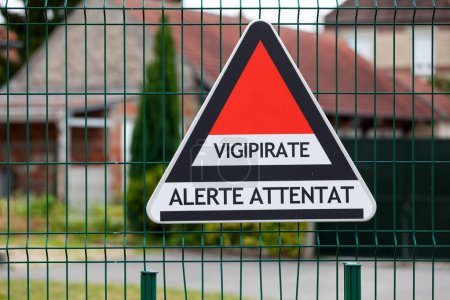Photo for Triangular sign attached to a school fence for the Vigipirate plan, the France's national security alert system against terrorist threats. - Royalty Free Image