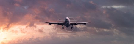 Téléchargez les photos : Vue panoramique d'un avion de ligne Turboréacteur atterrissant au coucher du soleil. - en image libre de droit