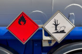Dangerous goods signs on a tank truck side. The red placard indicate the good is a Flammable Liquid and the one that it is also an Environmentally Hazardous Substance. Stickers #642006492