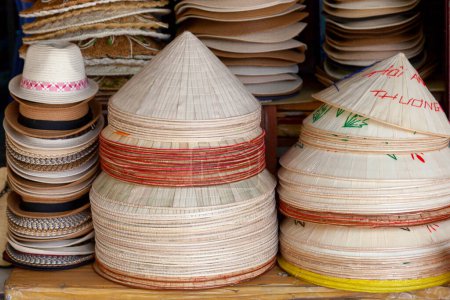 Photo for Straw hats for sale on the stalls of a shophouse in Hoi An, Vietnam. - Royalty Free Image