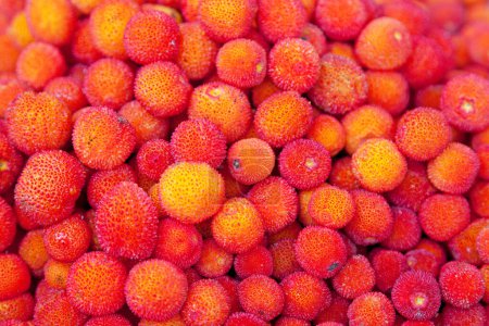 Photo for Close-up on a stack of Arbutus berries for sale on a market stall. - Royalty Free Image