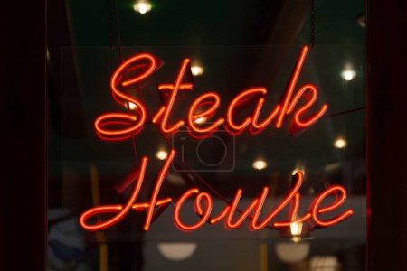 Téléchargez les photos : Lumière au néon rouge en forme de mots "Steak house". - en image libre de droit