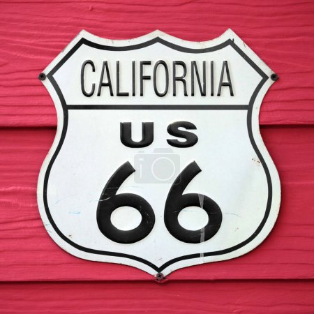 Téléchargez les photos : Gros plan sur un panneau de route California US 66 vissé sur un mur en bois peint en rouge. - en image libre de droit