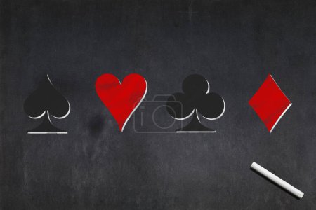 Téléchargez les photos : Tableau noir avec la bêche, le cœur, le club et le diamant dessinés au milieu. - en image libre de droit