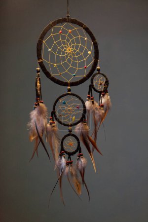 Close-up on a Dreamcatcher hanging in a dark room.