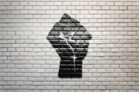 Téléchargez les photos : Gros plan sur un symbole de poing levé de la Révolution noire peint sur un mur de faïence blanche du métro de Paris. - en image libre de droit
