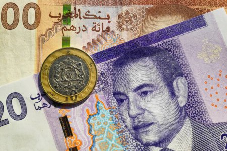 Nahaufnahme einer 10 marokkanischen Dirham-Münze auf einer Banknote zu 20 und 100.