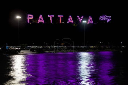 Photo for Neon sign of Pattaya City at the bottom of Pattaya hill, by the sea, with speedboats parked for the night. - Royalty Free Image