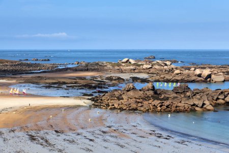 Foto de La playa de la huelga blanca (Greve Blanche) en Tregastel con pequeños barcos navegando entre rocas de granito y la isla de los conejos (Ile aux Lapins). - Imagen libre de derechos