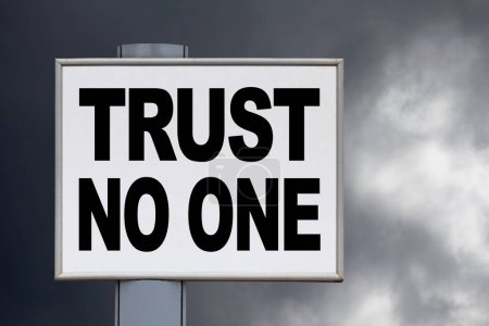 Téléchargez les photos : Gros plan sur un panneau blanc contre un ciel orageux avec le message "Ne faites confiance à personne" écrit au milieu. - en image libre de droit