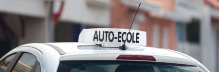 Téléchargez les photos : Panneau de toit blanc avec inscription en français "Auto-Ecole", signifiant en anglais "Driving school"". - en image libre de droit
