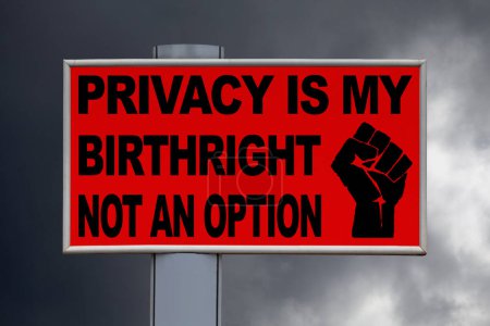 Téléchargez les photos : Gros plan sur un panneau rouge contre un ciel nuageux avec le message "La vie privée est mon droit d'aînesse, pas une option" écrit au milieu à côté d'un poing levé. - en image libre de droit