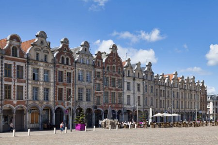 Foto de Arras, Francia - 22 de junio de 2020: Edificios góticos llamativos con frontones flamencos y arcadas a lo largo de la Place des Heros en el centro de la ciudad. - Imagen libre de derechos