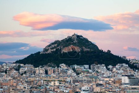 Cityscape of Athens at sunset with the Church of St George on top of Mount Lycabettus.