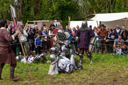 Photo for Locronan, France - May 07 2023: Group of men in medieval armor fighting during a buhurt demonstration. - Royalty Free Image