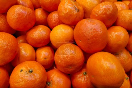 Close-up on a stack of mandarin oranges on a market stall.