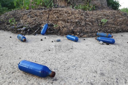 Several nitrous oxide canisters abandoned in the street after their use.