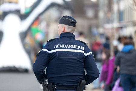 Téléchargez les photos : Landerneau, France - 03 avril 2022 : Gendarme surveille la foule pendant le carnaval de Landerneau. - en image libre de droit