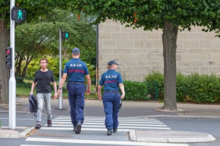Téléchargez les photos : Caen, France - 21 juillet 2017 : Deux agents de l'A.S.V.P. (Agent de surveillance de la voie publique) patrouille dans les rues à pied. Ces agents ont le devoir d'aider la police locale à surveiller, mais leurs actions sont vraiment limitées.. - en image libre de droit