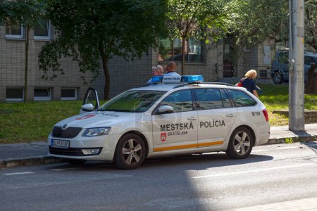 Foto de Bratislava, Eslovaquia - 18 de junio de 2018: Dos policías eslovacos de la Mestska Policia fuera de su coche de policía. - Imagen libre de derechos