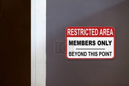 Panneau rouge et blanc sur le côté d'une porte ouverte indiquant : Zone réglementée, membres seulement au-delà de ce point.
