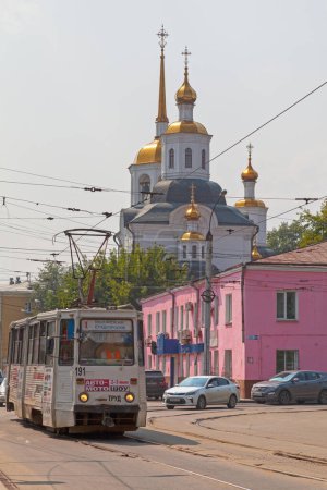 Téléchargez les photos : Irkoutsk, Russie - 27 juillet 2018 : Tramway passant par l'église Kharlampiev, une église orthodoxe située dans le centre historique de la ville sur la 5e rue de l'Armée. - en image libre de droit